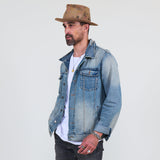 Man wearing a denim jacket and brown hat against a white background