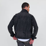 Man wearing a black denim jacket and jeans on a white background
