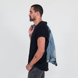 Man wearing a black t-shirt, gray jeans against a white background