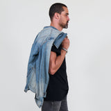 Man wearing a denim jacket, black shirt, gray jeans on a white background