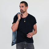 Man wearing a black t-shirt, gray jeans on a white background