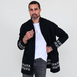 Man wearing a black cardigan with white patterns, white shirt and gray jeans on a white background