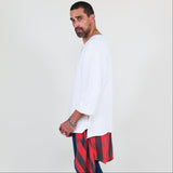 Man wearing a white sweater and blue jeans on a white background