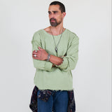 Person wearing a light green shirt and blue pants on a white background