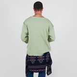 Person wearing a light green shirt and blue pants on a white background