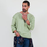 Person wearing a light green shirt and blue pants on a white background