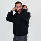 Person wearing a black hoodie and against a white background