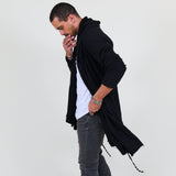 Man wearing a black shawl, white shirt, gray pants on a white background