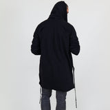 Man wearing a black shawl, white shirt, gray pants on a white background