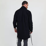 Man wearing a black shawl, white shirt, gray pants on a white background