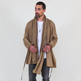 Man wearing a beige shawl, white shirt, gray pants on a white background