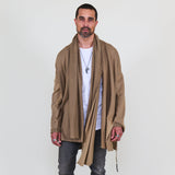 Man wearing a beige shawl, white shirt, gray pants on a white background