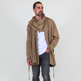 Man wearing a beige shawl, white shirt, gray pants on a white background