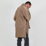 Man wearing a beige shawl, white shirt, gray pants on a white background