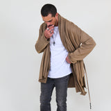 Man wearing a beige shawl, white shirt, gray pants on a white background