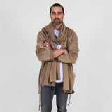 Man wearing a beige shawl, white shirt, gray pants on a white background