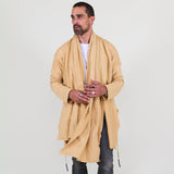 Man wearing a beige shawl, white shirt, gray pants on a white background