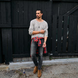 Man wearing a gray long sleeve tee and dark jeans