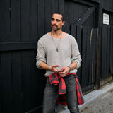 Man wearing a gray long sleeve tee and dark jeans